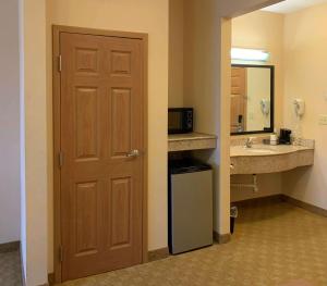 eine Tür zu einem Bad mit einem Waschbecken und einer Mikrowelle in der Unterkunft Sleep Inn & Suites Gettysburg in Gettysburg