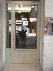 a door with a reflection of a person standing outside at Argo in Thessaloniki