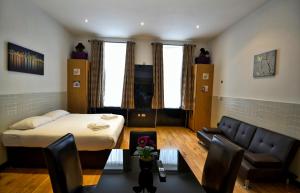 a small room with a bed and a couch at Hyde Park Apartments in London