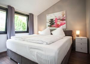a bedroom with a large bed with white sheets at Margaritenweg 31-F in Winterberg