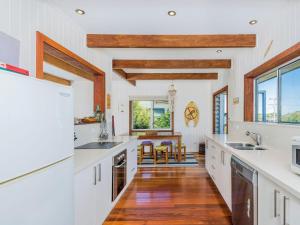 a kitchen with white counters and wooden ceilings at Pacifica Unit 1 in Brooms Head