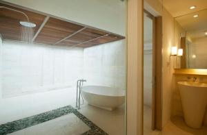 a bathroom with a bath tub and a sink at Holiday Inn Resort Baruna Bali by IHG in Kuta
