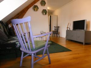 a rocking chair in a living room with a tv at Studio Hugo in Nijmegen