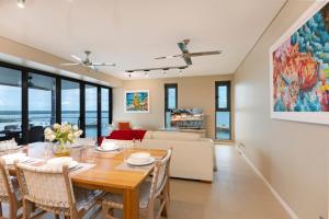 a dining room and living room with a table and chairs at Darwin Waterfront Luxury Suites in Darwin