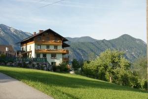 a house on a hill with mountains in the background at Familienbauernhof Christa in Rossleithen