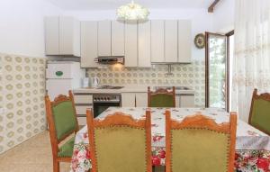 una cucina con tavolo, sedie e frigorifero di Apartment Gorda - 50m from the sea a Kaštela (Castelli)