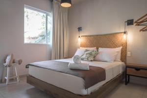 a bedroom with a large bed with a window at Agam Hotel in Bacalar
