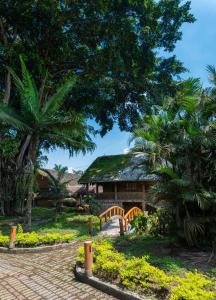 un edificio con ponte in un giardino alberato di Hotel Zaracay a Santo Domingo de los Colorados