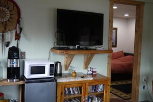 uma pequena cozinha com um micro-ondas e uma televisão em Five Peaks em Buena Vista