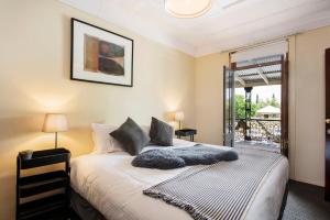 una camera da letto con un letto con lenzuola bianche e una finestra di The Woolpack Hotel a Mudgee