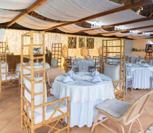 una sala da pranzo con tavoli, sedie e tenda di Hotel Zaracay a Santo Domingo de los Colorados Altre 76 foto