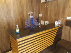 Een man met een masker draagt een stropdas. bij Hotel Rani and Rani Residency in Pondicherry