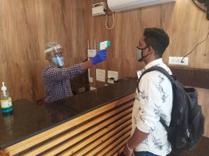 a man taking a picture of himself in a mirror at Hotel Rani and Rani Residency in Puducherry