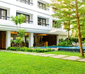 an exterior view of a building with a yard at UMA Residence in Bangkok