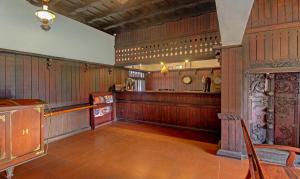 AlleppeyにあるTreebo Tryst Travancore Palace Cherthalaのウッドパネルの広い客室で、バーが備わります。