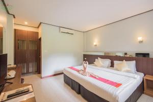 a bedroom with a large bed with slippers on it at Chai Chet Resort Koh Chang in Ko Chang