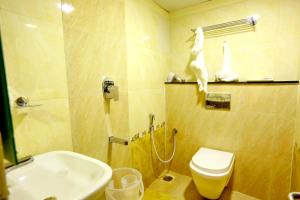 a bathroom with a sink and a toilet and a shower at HOTEL KEK GRAND PARK in Chennai