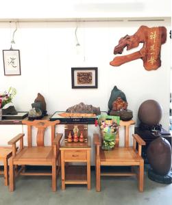 um quarto com mesas e cadeiras de madeira e fatos em 蒔光漫築民宿 em Ting-liao