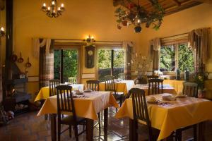 a dining room with tables and chairs with yellow table cloth at Pousada Villa Rhústica in Santo Antônio do Pinhal