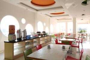 - une salle à manger avec des tables, des chaises et des fenêtres dans l'établissement Hotel Dewarna Sutoyo Malang, à Malang
