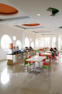 - un restaurant avec des tables, des chaises et des tables dans l'établissement Hotel Dewarna Sutoyo Malang, à Malang