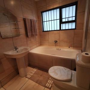 a bathroom with a tub and a toilet and a sink at The Hide on Devereux in East London +19 photos