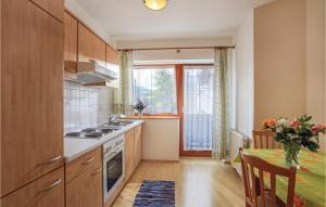 a kitchen with wooden cabinets and a table and a window at Amazing Apartment In Kirchberg With 2 Bedrooms And Wifi in Kirchberg in Tirol