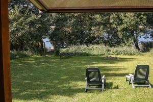 two chairs sitting in the grass in a yard at Domki Nad Jeziorem "Półwysep SURYTY" in Suryty