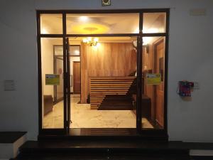 - une porte en verre dans une chambre avec un escalier dans l'établissement Hotel Rani and Rani Residency, à Pondichéry