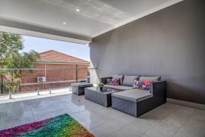 a living room with a couch and a large window at Maylands Boutique Apartments in Perth