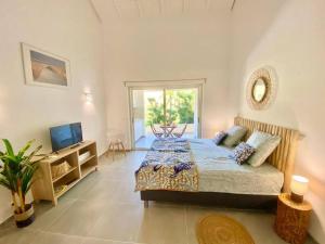 ein Schlafzimmer mit einem Bett und einem TV in der Unterkunft Beautiful suite S15, pool, next to Pinel Island in Cul de Sac