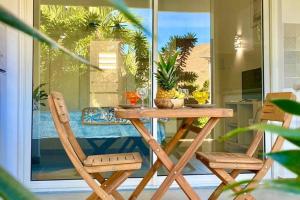 een houten tafel en stoelen op een veranda bij Beautiful suite S15, pool, next to Pinel Island in Cul de Sac