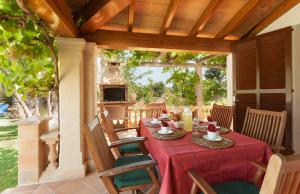 een tafel met een rode tafelkleed en stoelen op een patio bij Cal Roma in Pollença