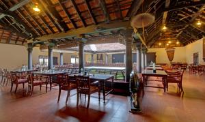 AlleppeyTreebo Premium Travancore Palace Cherthala的一个带桌椅的用餐室和一个游泳池