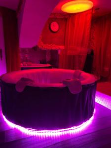 Zimmer mit einer runden Badewanne mit violetten Lichtern in der Unterkunft Gasthaus Luggwirt in Gnesau