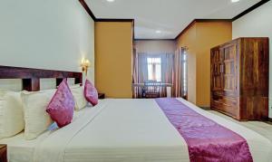 Treebo Premium Travancore Palace Cherthala客房内的一张或多张床位