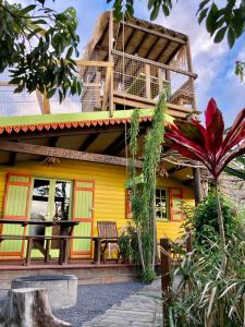 une maison jaune avec un balcon au-dessus dans l'établissement Le Repaire du Dodo, à La Saline Les hauts 