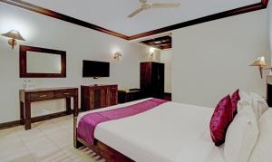 Treebo Premium Travancore Palace Cherthala的电视和/或娱乐中心