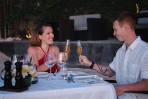a man and woman sitting at a table with wine glasses at The Chill Resort and Spa, Koh Chang in Ko Chang