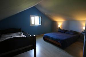 a blue bedroom with two beds and a window at lebonair in Salazie
