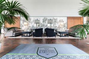 a living room with chairs and a table and palm trees at Sannäsin Kartano in Porvoo