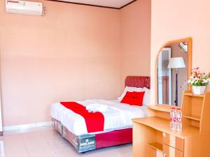 um quarto com uma cama com um cobertor vermelho em RedDoorz near Reremi Pemancar Manokwari em Manokwari