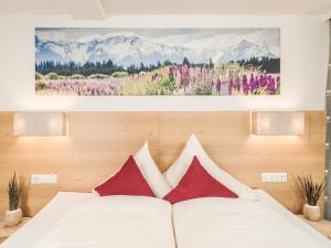 a bedroom with a bed with red and white pillows at Leitnerhof in Ramsau im Zillertal