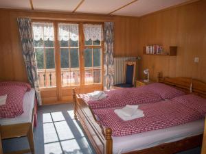 a bedroom with two beds and a window at Chalet Sturmfang in Adelboden