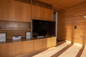 sala de estar con TV grande y paredes de madera. en Baldrian C14, en Adelboden