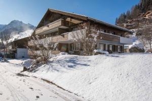 una casa en la nieve delante en Baldrian C14, en Adelboden