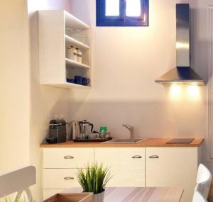 a kitchen with white cabinets and a sink at Psathi Blue Beta in Kimolos
