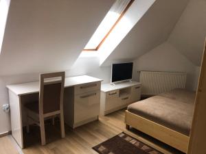 a bedroom with a desk with a computer and a bed at Mol-Ker-Vill Apartment in Lenti