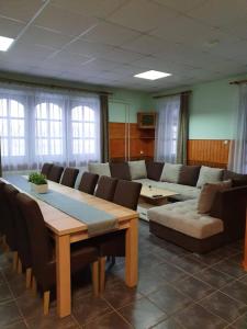 Tó úti Vendégház في Mezőtúr: غرفة مع طاولة وكراسي وأريكة