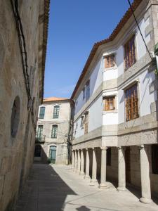 an alley between two buildings in a city at Hotel Tres Carabelas in Baiona
